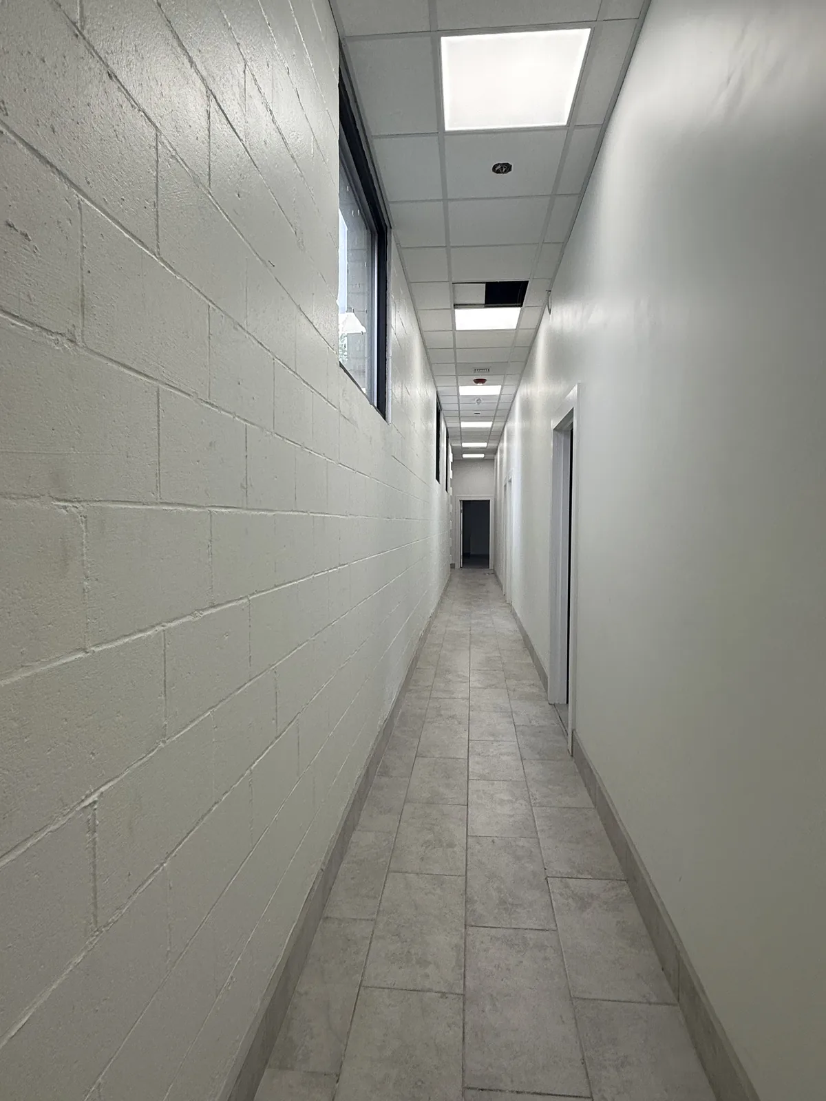 Tiled rear hallway behind the units, with painted block walls and new lighting